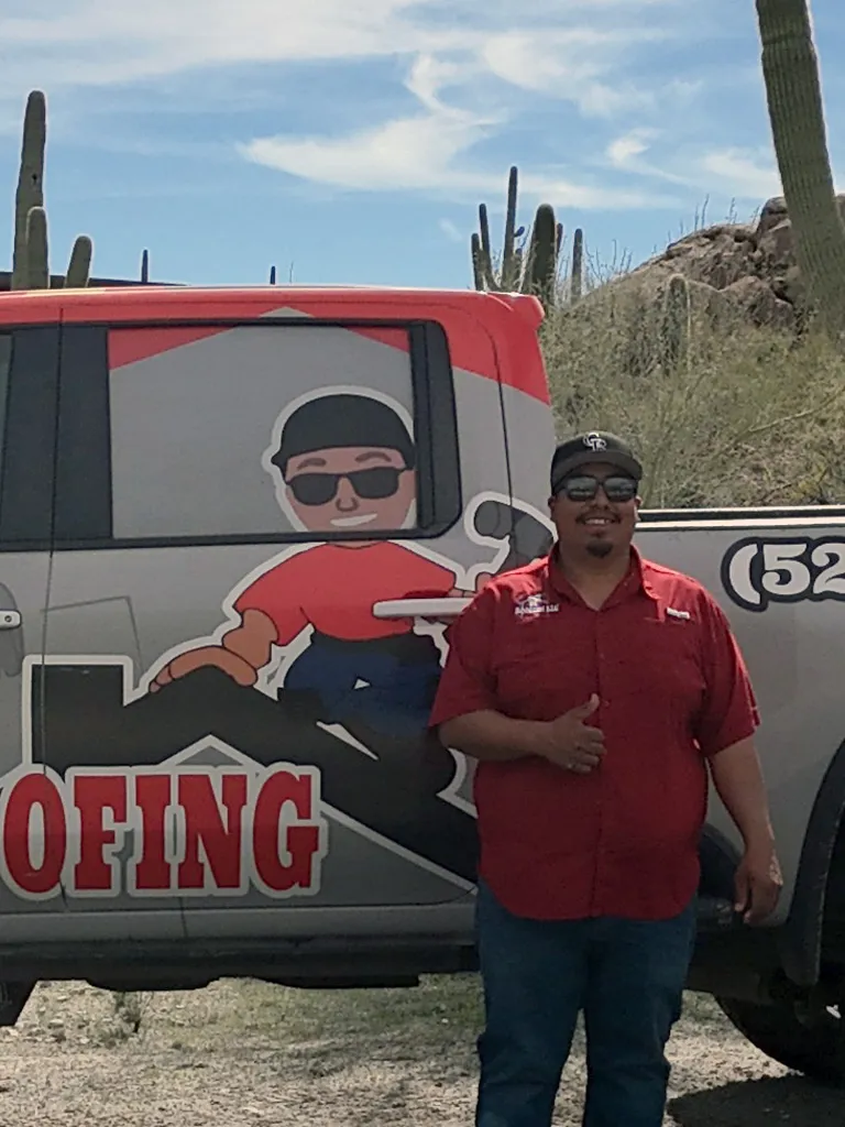 David Contreras, owner of DC Roofing of Arizona, standing in front of his branded truck in the Sonoran Desert