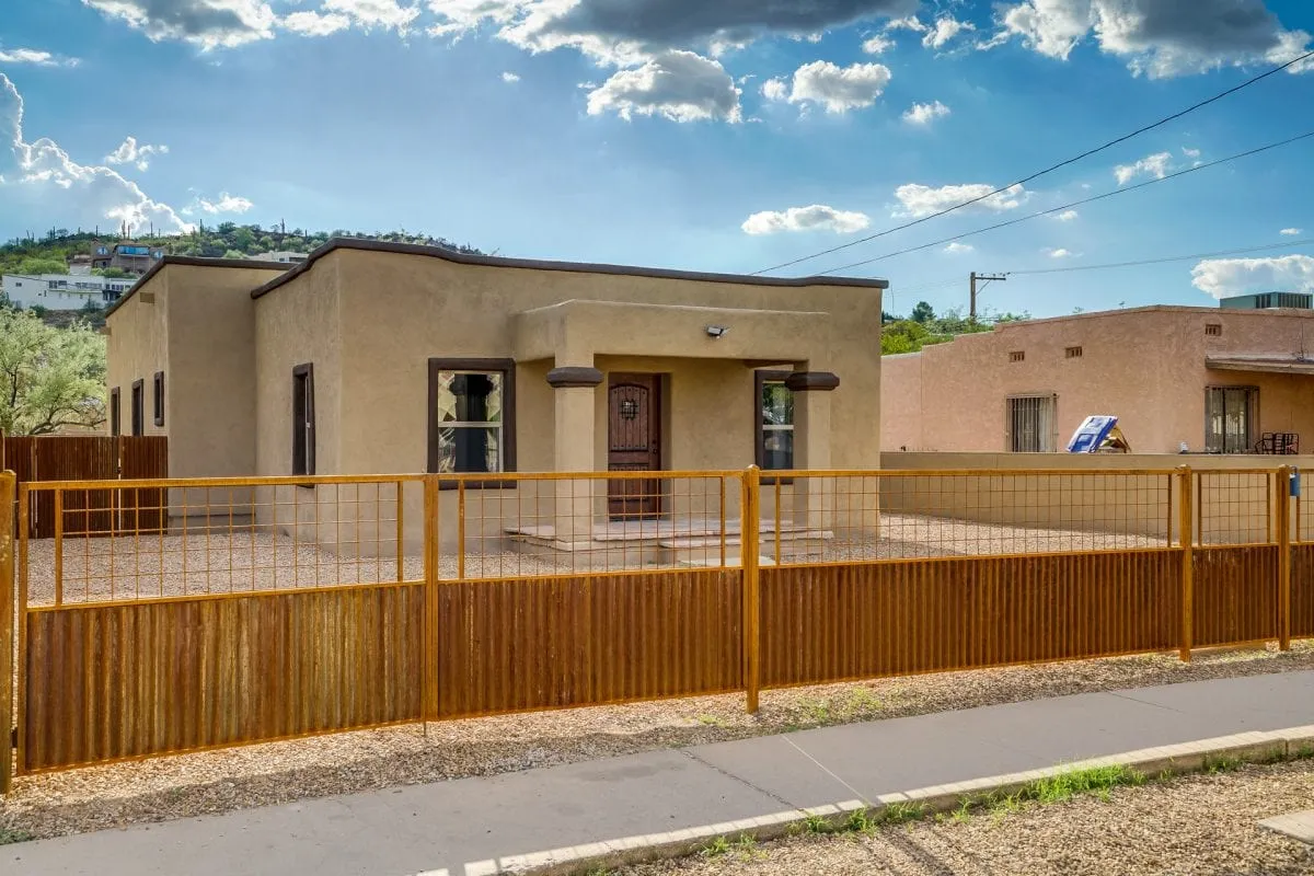 Single-family stucco home behind a corrugated metal fence on South Westmoreland Avenue in the Menlo Park neighborhood of Tucson