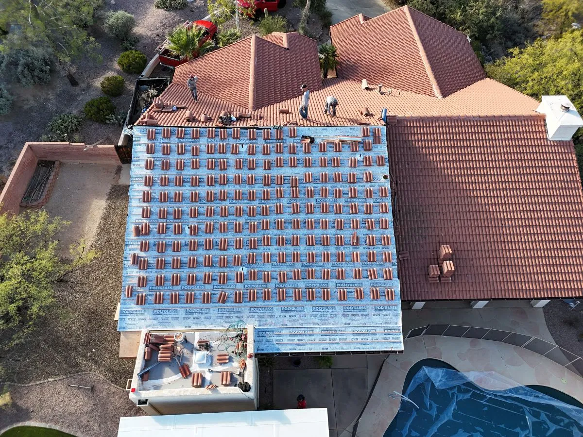 DC Roofing crew installing tile roof on a large Marana home, aerial drone view