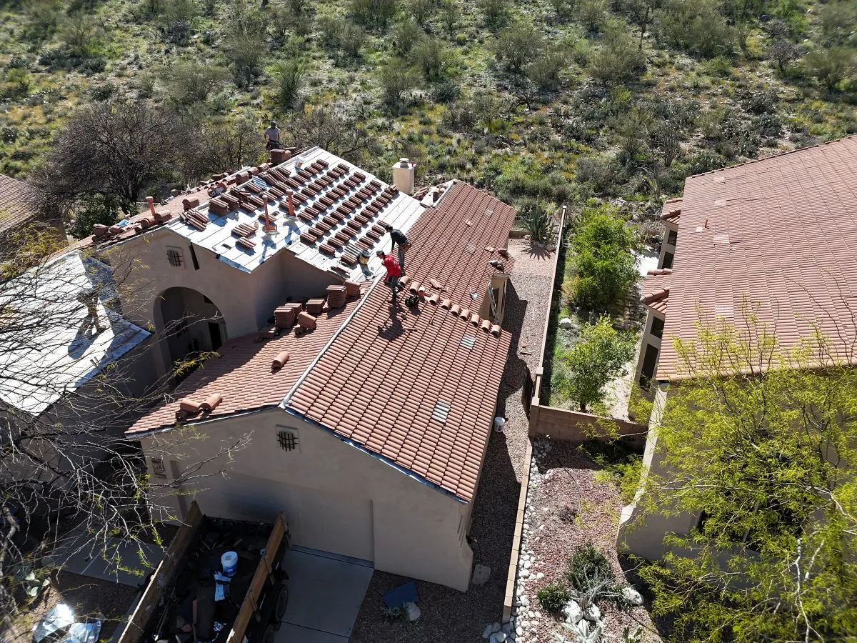 DC Roofing crew on a tile roof replacement in Sahuarita with Sonoran Desert hillside backdrop